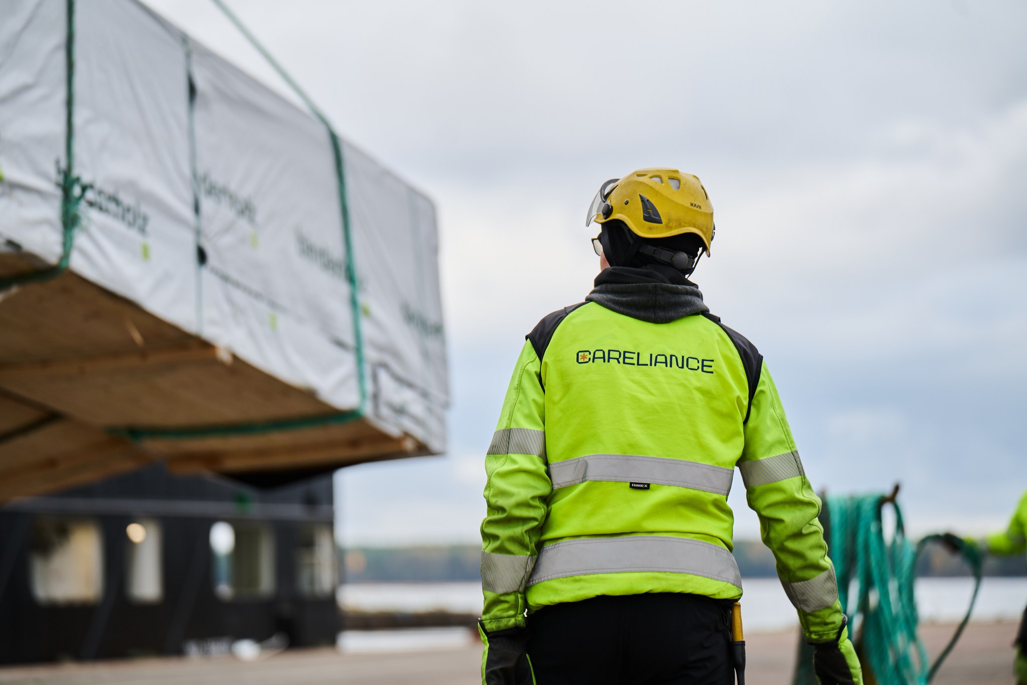 A Careliance employee at the port beside a load of sawn timber.